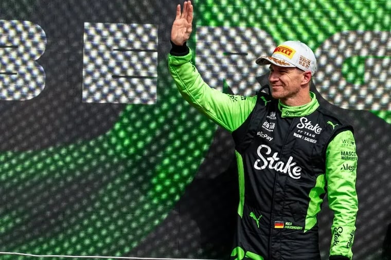 race-car-driver-waving-green-suit